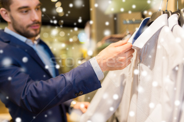 close up of man choosing shirt in clothing store Stock photo © dolgachov