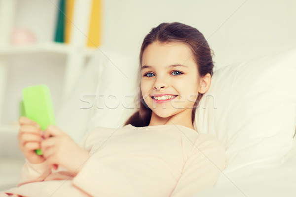 Happy girl bed smartphone domu ludzi dzieci Zdjęcia stock © dolgachov