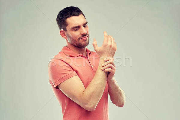 unhappy man suffering from pain in hand Stock photo © dolgachov