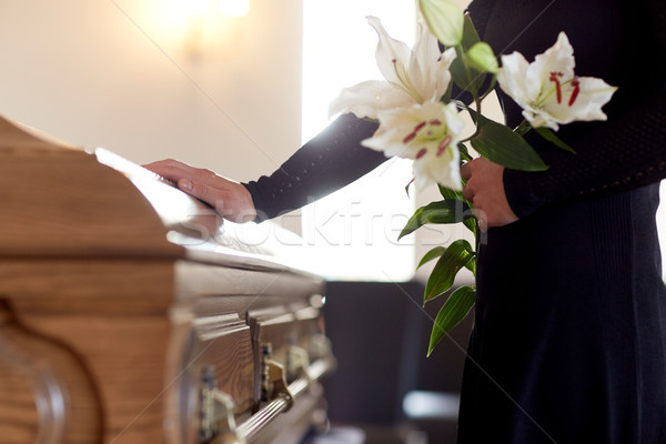 woman with lily flowers and coffin at funeral Stock photo © dolgachov
