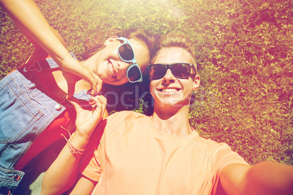 happy teenage couple taking selfie on summer grass Stock photo © dolgachov
