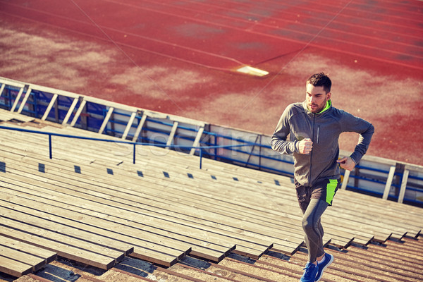 Jonge man lopen naar boven stadion fitness sport Stockfoto © dolgachov
