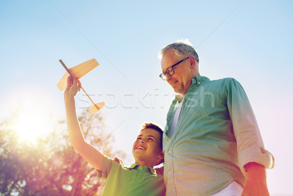 senior man and boy with toy airplane over sky Stock photo © dolgachov