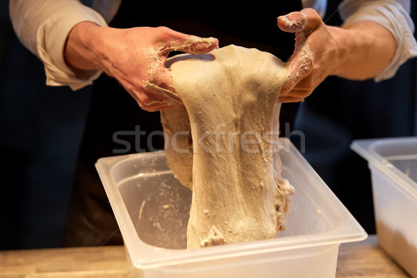 close up of baker hands making bread dough Stock photo © dolgachov