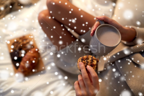 close up of woman with cocoa cup and cookie in bed Stock photo © dolgachov