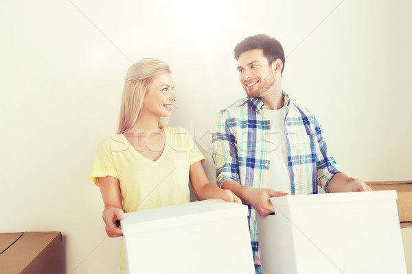 smiling couple with big boxes moving to new home Stock photo © dolgachov