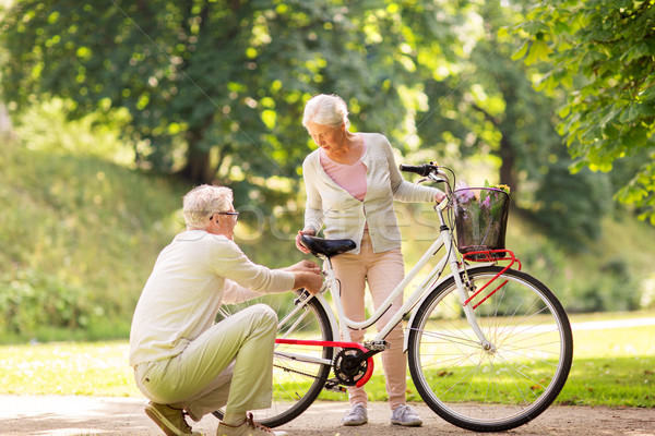 happy senior couple with bicycle at summer park Stock photo © dolgachov