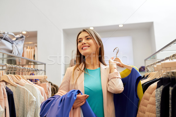 快樂 年輕女子 選擇 衣服 購物中心 購物 商業照片 © dolgachov