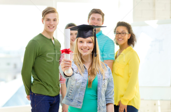 smiling female student with diploma and corner-cap Stock photo © dolgachov