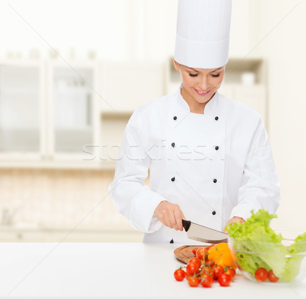 Stock photo: smiling female chef chopping vegetables