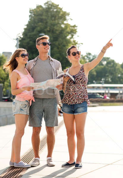 smiling friends with map and city guide outdoors Stock photo © dolgachov