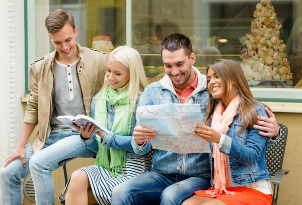 group of friends with guide and map exploring town Stock photo © dolgachov