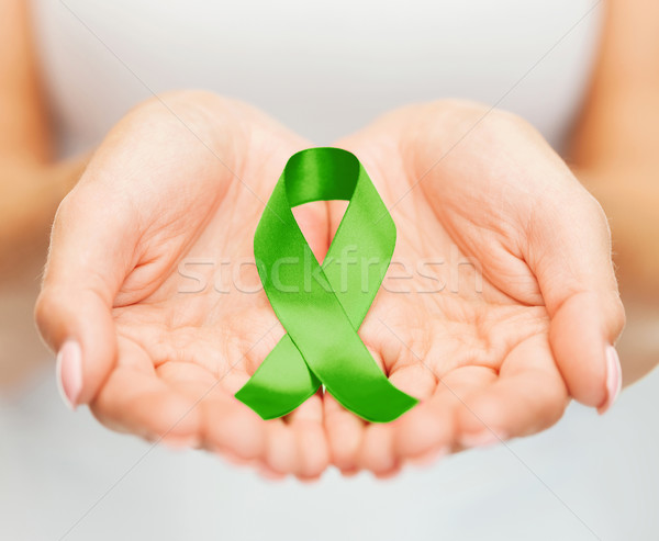 hands holding green awareness ribbon Stock photo © dolgachov