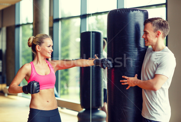 smiling woman with personal trainer boxing in gym Stock photo © dolgachov
