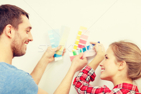 Stock photo: smiling couple looking at color samples at home