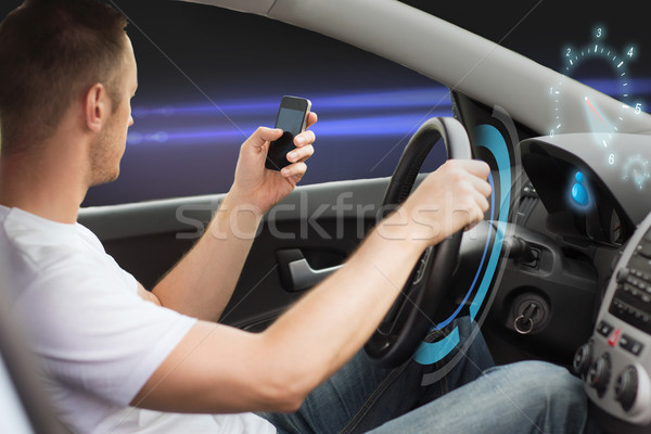 man looking to smart phone while driving car Stock photo © dolgachov