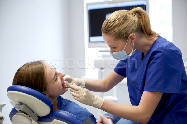 female dentist checking patient girl teeth Stock photo © dolgachov