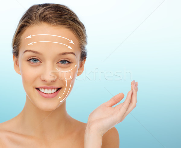 smiling young woman with white arrows on face Stock photo © dolgachov