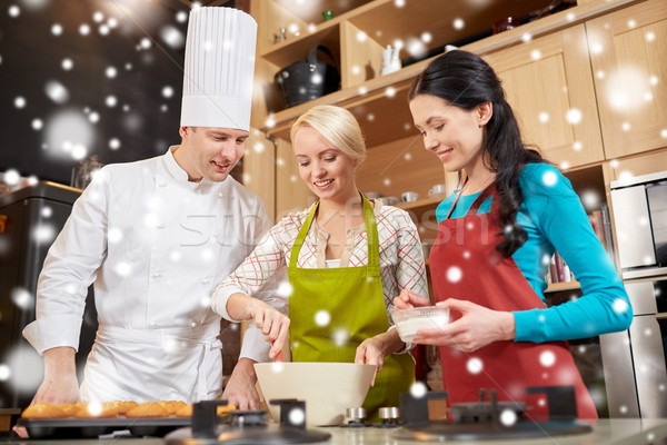 happy women and chef cook baking in kitchen Stock photo © dolgachov