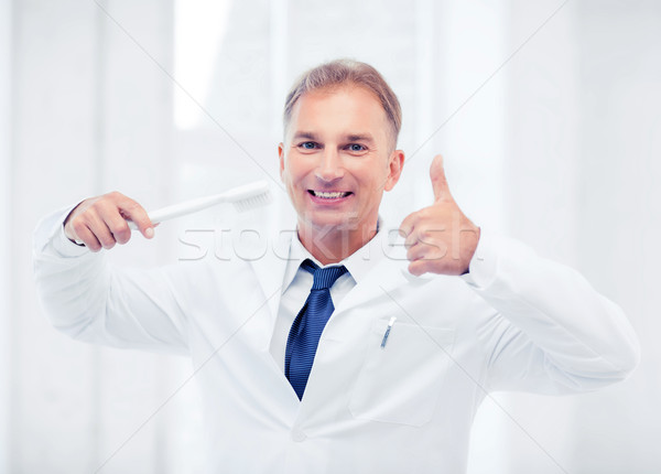 Stock photo: dentist with toothbrush in hospital