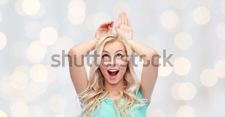 happy smiling young woman making bunny ears Stock photo © dolgachov