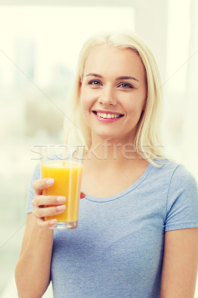 Donna sorridente bere succo d'arancia home cibo vegetariano Foto d'archivio © dolgachov