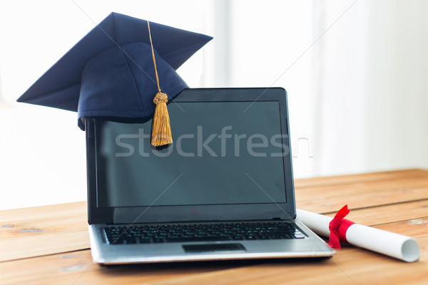 close up of laptop with mortarboard and diploma Stock photo © dolgachov