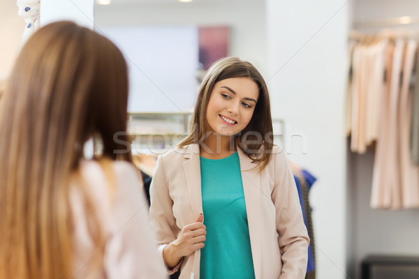 happy woman posing at mirror in clothing store Stock photo © dolgachov