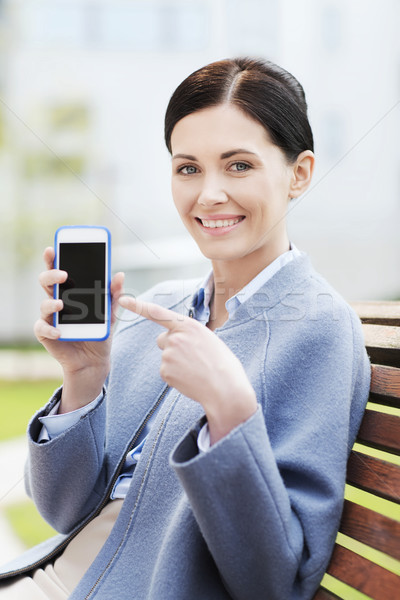 Stock photo: young smiling businesswoman showing smartphone