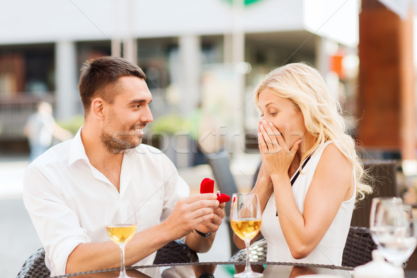 Stock photo: happy couple with engagement ring and wine at cafe