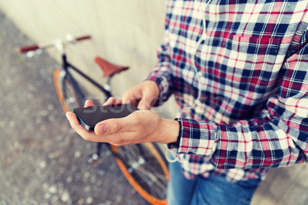 close up of hipster man with smartphone and bike Stock photo © dolgachov