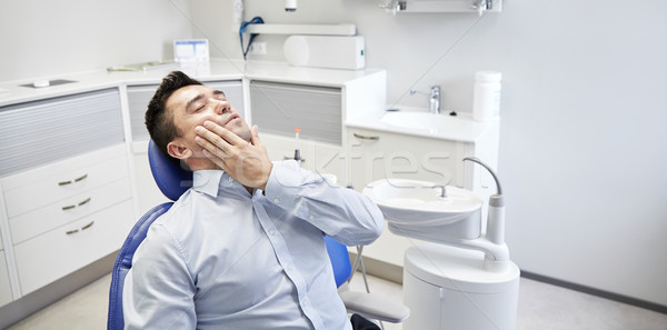 Uomo mal di denti seduta dental sedia persone Foto d'archivio © dolgachov