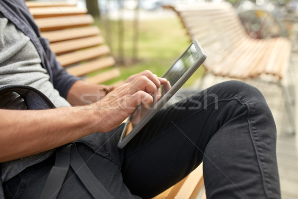 close up of man with tablet pc sitting on bench Stock photo © dolgachov