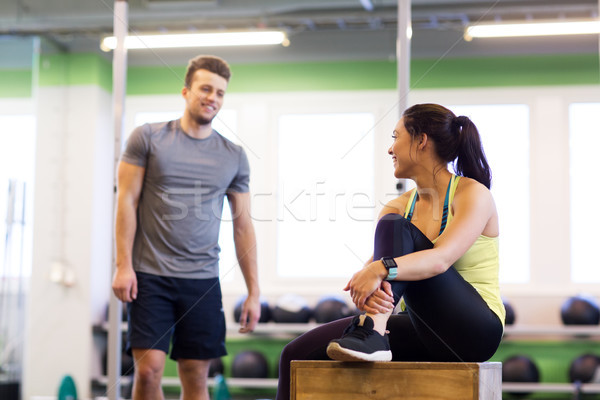 Stock photo: happy man and woman with heart rate tracker in gym