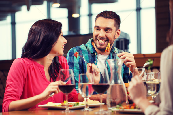 happy couple with friends eating at restaurant Stock photo © dolgachov