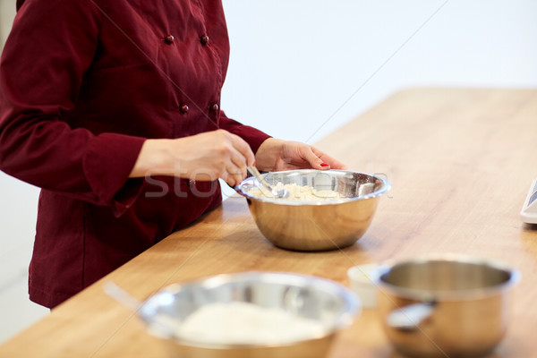 chef with flour in bowl making batter or dough Stock photo © dolgachov