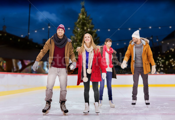 happy friends on christmas skating rink Stock photo © dolgachov
