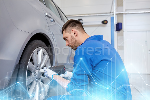 Stock photo: mechanic with screwdriver changing car tire