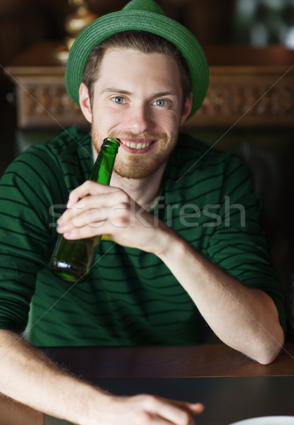 man drinking beer from green bottle at bar or pub Stock photo © dolgachov