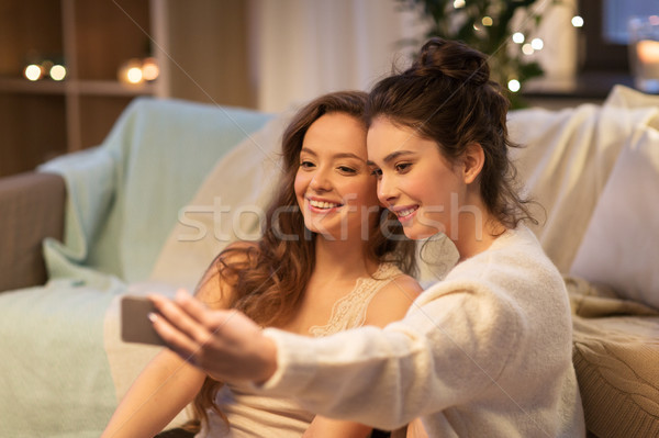 female friends taking selfie by smartphone at home Stock photo © dolgachov
