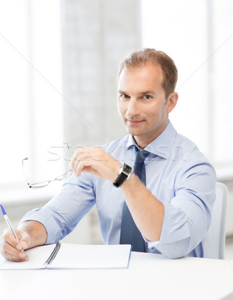 Biznesmen okulary piśmie notebooka zdjęcie przystojny Zdjęcia stock © dolgachov