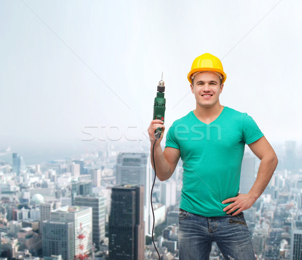 smiling manual worker in helmet with drill machine Stock photo © dolgachov