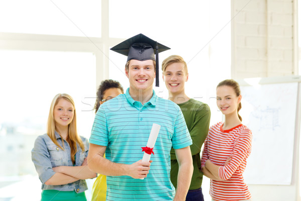 smiling male student with diploma and corner-cap Stock photo © dolgachov
