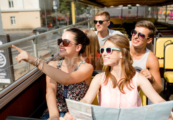 group of smiling friends traveling by tour bus Stock photo © dolgachov