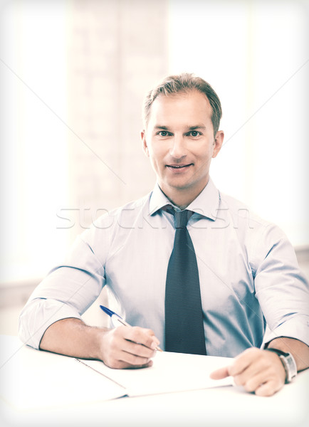 Stock photo: handsome businessman writing in notebook