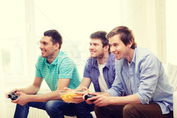 Glimlachend vrienden spelen video games home vriendschap Stockfoto © dolgachov