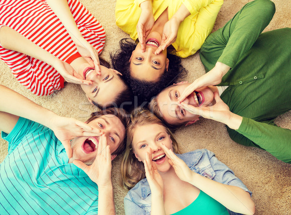 smiling people lying down on floor and screaming Stock photo © dolgachov