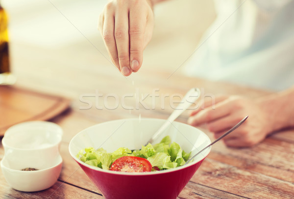 close up of male hands flavouring salad in a bowl Stock photo © dolgachov