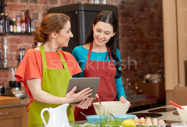 happy women with tablet pc cooking in kitchen Stock photo © dolgachov