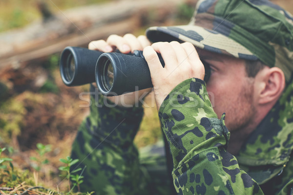 young soldier or hunter with binocular in forest Stock photo © dolgachov